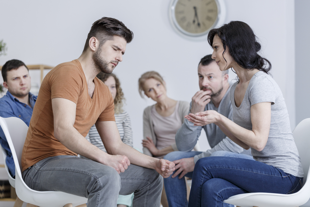 young,woman,talking,to,tense,man,during,anger,management,class